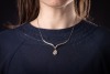 A diamond-set necklace, composed of a V-shaped bar, with diamond-set chevron detailing, suspending a pear-shaped diamond-set pendant, to a box-link chain measuring approximately 42cm, in white metal stamped &lsquo;585&rsquo;; 8.4 grams - 5