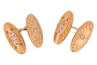 A pair of diamond-set cufflinks, of elongated oval form with repousse design, one panel centred with a star-set old-cut diamond, the other pave-set with a row of three old-cut diamonds in a navette mount, connected by a figure of eight link, unmarked yell
