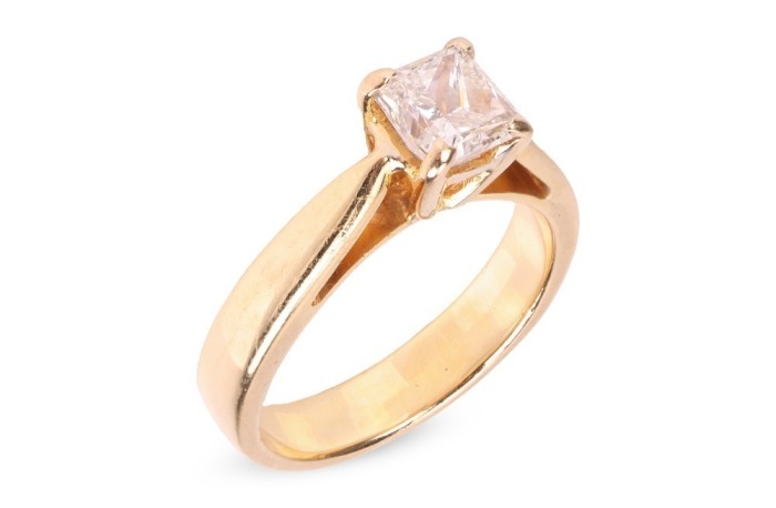 A diamond solitaire ring, featuring a central claw-set princess-cut diamond of estimated 0.44ct, to tapered shoulders leading to a yellow metal ring shank marked &lsquo;750&rsquo;, size H &frac12;, 4.2 grams.