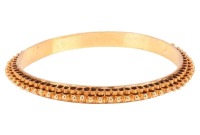 A closed bangle, decorated with tiered fluting borders and bead details, yellow metal unmarked surface testing as 14ct, inner diameter 5.7 cm, 19.9 grams. Please note: Unless otherwise stated, lots have been tested using an electronic tester. This is a su