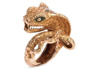 A cobra cocktail ring, sculpted as a spiralling cobra, with geometric patterns on the back, set with green and red enamel, yellow metal stamped 'K18', size L, 12.5 grams.