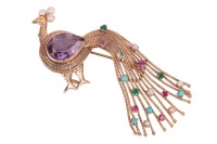 A gem-set peacock brooch, the body set with a large pear-cut synthetic colour-change sapphire, to a mount composed of twisted cables, tail scattered with claw-set gemstones such as turquoise cabochon and circular-cut emeralds, etc., crown embellished with