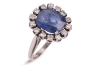 A sapphire and diamond cluster ring, centred with a cushion-cut blue sapphire, measuring 10.8 x 9.4 x 4.0 mm, encircled with fourteen single-cut diamonds, leading to a D-profile shank in unmarked white metal, surface testing as 18ct, ring head 1.8 x 1.6 c