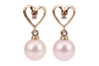 A pair of cultured Akoya pearl and diamond drop earrings; the pearls of approximately 6.5mm each, of creamy ground with silver-pink lustre, suspended from an open heart-shaped stud, with a diamond accent, set in unmarked yellow metal surface testing as 9c