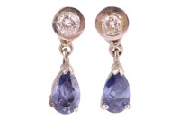 A pair of paste and diamond drop earrings, each claw-set with a purple pear-cut paste, with single-cut diamond surmount, peg and butterfly fittings, in white metal surface testing as 9ct, 1.8 cm drop, 3.5 grams. Please note: Unless otherwise stated, lots 