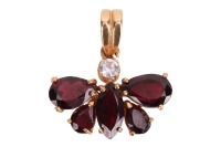 A garnet butterfly pendant, with a round colourless spinel highlight, four pear-shaped garnets and a marquise garnet, assembled as a figural butterfly, claw set on a yellow precious metal mount, to a bail, marked as '750', overall measuring 1.4 x 2.1 cm, 