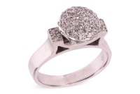 A diamond-set dress ring, the raised circular setting, pav&eacute;-set with round brilliant cut diamonds, flanked by two diamond-set panels with millegrain detailing, in a white metal mount marked &lsquo;750&rsquo;, size N; 6.5 grams