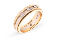 Boodle & Dunthorne - a two-toned Amar&eacute; ring in 18ct gold; the central recessed band set with three round brilliant-cut diamonds, estimated total weight 0.30ct, signed, London 2000, size L, 7.5 grams. Boxed, no papers.