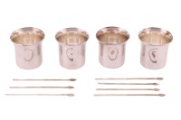 A set of four Swedish white metal punch cups designed by Karl Axel Karlsson; the slightly tapering hand hammered cups, with full Swedish silver marks for 1989 and Karlsson's maker's mark, 5cm high. Together with a set of six cocktail sticks,1988, by the s