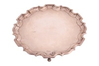 An early 20th century silver salver; circular with Chippendale border, on three scroll feet. Sheffield 1922 by Lee & Wigfull. 37cm diam. 36.5ozt.