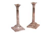 A pair of George III silver Corinthian column table candlesticks, Sheffield 1777, possibly an early work of Thomas Watson & Co, with removable nozzles and pierced capitols on fluted shafts and concave neoclassical embossed bases with oval armorial boss (L