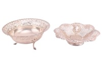 An Edwardian pierced silver circular fruit basket, Sheffield 1909 by James Dixons & Sons, with cast and applied gadrooned rim above a pierced trellis band, supported on three shaped legs, 25.5 cm diameter, together with a die-stamped silver fruit stand on